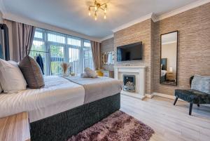 een slaapkamer met een groot bed en een open haard bij Stunning 5 Bed House - Sleeps 9, Central Solihull, NEC, JLR, HS2, Resorts World, Airport Business and Leisure Stays, in Solihull