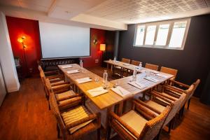 uma sala de jantar com uma mesa longa e cadeiras em Hôtel des Isles em Barneville-Carteret