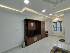 a living room with a flat screen tv on a wall at Firefly Resort in Kanthalloor