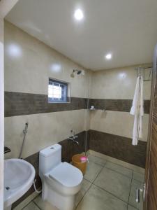 a bathroom with a toilet and a sink at Firefly Resort in Kanthalloor