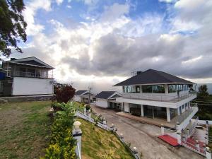 a large white house with a lot of windows at Firefly Resort in Kanthalloor