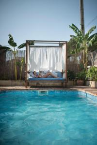 un hombre acostado en una cama junto a una piscina en Ca n'Alorda Holiday Home Cala Llombards piscina, wifi, seguridad y relax, en Santanyí