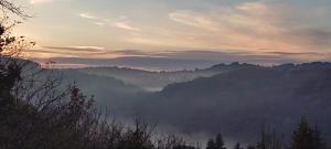 a view of a mountain valley at sunset at Quercynoise de Charme Piscine et vue sur Vallée du LOT in Balaguier-dʼOlt
