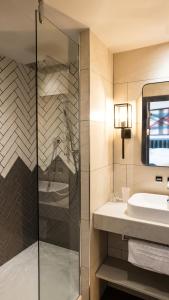 a bathroom with a shower, sink, and mirror at Hotel Indigo Manchester - Victoria Station, an IHG Hotel in Manchester