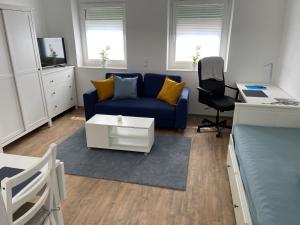 sala de estar con sofá azul y escritorio en Apartment in Mayen Zentrum nur 100 Meter, en Mayen