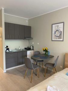 a kitchen and dining room with a table and chairs at Apartament Etna in Kołobrzeg