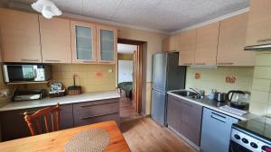 a kitchen with wooden cabinets and a table in a room at Apartamenty Wieżyca in Szymbark