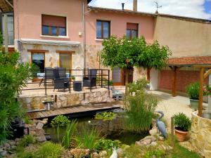 a house with a garden and a pond at Chambre d'hôtes Juline 