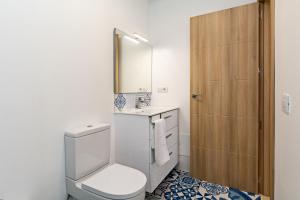 Un baño con inodoro, lavabo y espejo. en Villa Pilak, en Playa Blanca 23 fotos más