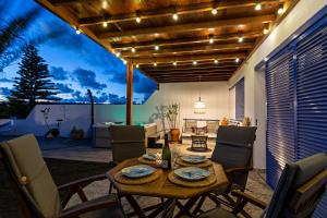 Un patio con una mesa con sillas y un comedor. en Villa Pilak, en Playa Blanca