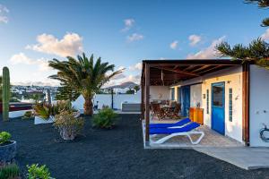a small house with a blue door and a patio at Villa Pilak in Playa Blanca