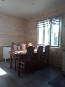 a dining room with a wooden table and chairs at Suvantorinne 