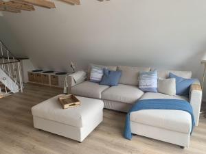 a living room with a white couch and blue pillows at Glückshaus in Brodersby