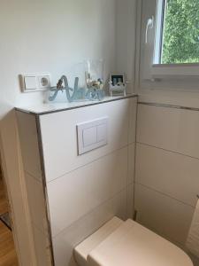 a white bathroom with a toilet and a window at Glückshaus in Brodersby +18 photos