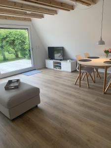 a living room with a large window and a table and chairs at Glückshaus in Brodersby