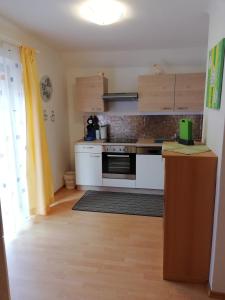 a kitchen with white appliances and a wooden floor at Haus Anika Ferienwohnung in Mallnitz