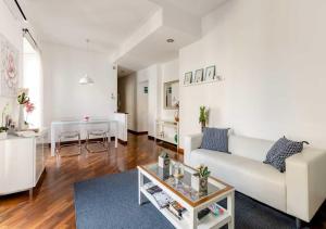 ローマにあるRomely House St Peter Apartmentのリビングルーム(白いソファ、テーブル付)