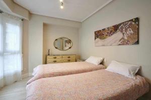 a bedroom with two beds and a mirror at Apartamento Marina de Pasaia in Pasai San Pedro