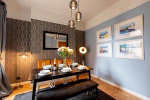 a dining room with a table with chairs and flowers at SO-LUX in Belfast
