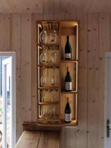 a cabinet filled with glasses and wine bottles at Tiny House in Neusiedl an der Zaya