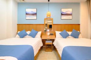 Giường trong phòng chung tại Blue Sea Hotel Quy Nhơn - 02 Trần Độc