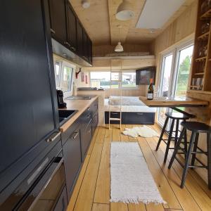 a kitchen with wooden floors and cabinets and a counter at Tiny House in Neusiedl an der Zaya