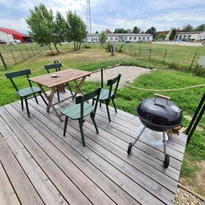 grill na drewnianym tarasie ze stołem piknikowym i krzesłami w obiekcie Tiny House w mieście Neusiedl an der Zaya