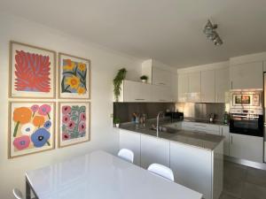 a kitchen with white cabinets and a white table at "A Marosa", bonito chalet dúplex in Cangas de Morrazo