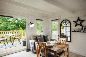 a living room with a couch and a table at Caban Du Bach Pembroke With Private Garden in Pembrokeshire