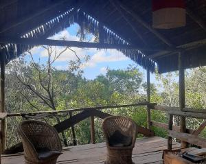 two chairs on a porch with a view of the forest at Aldea Zen Chales Privativos in Ouro Preto