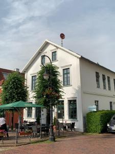 um edifício branco com uma luz de rua em frente em Schloss Blick Bredendiek OG em Jever