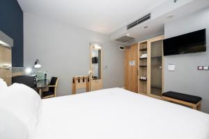 a living room with a bed and a tv in a room at Holiday Inn Express Barcelona City 22@, an IHG Hotel in Barcelona