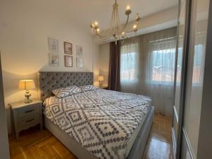 een slaapkamer met een bed en een kroonluchter bij Pupin Luxury Apartment in Ohrid