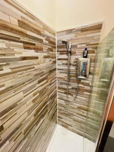 a bathroom with a shower with a tile wall at Charming 2-Bedroom Apartment Located in Ayr in Ayr