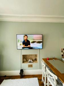 a tv hanging on a wall with a fireplace at Charming 2-Bedroom Apartment Located in Ayr in Ayr