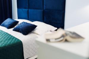 a bed with blue and white pillows on it at Apartamenty Silver 4 in Szczecin