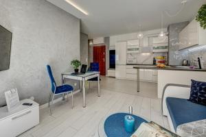 a kitchen and a living room with a table and chairs at Apartamenty Silver 4 in Szczecin +3 photos