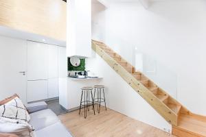 uma cozinha branca com uma escada e bancos em Cozy House w/ AC near metro by LovelyStay no Porto