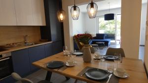 a dining room table with plates and wine glasses at Moselufer Apartments in Ürzig