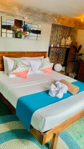 a bedroom with a large bed with towels on it at El Nido Family Room of hidden in El Nido