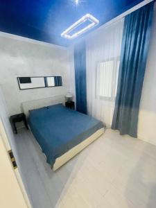 ママイア・ノルドにあるBoudoir Tropical Apartmentsの青い天井のベッドルーム1室(ベッド1台付)