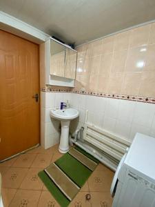 ein Bad mit einem Waschbecken und einem Spiegel in der Unterkunft Rozalinda Guesthouse in Naryn