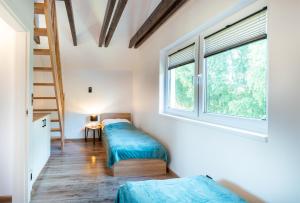 two beds in a room with a window and a ladder at Przystanek Lubiatowo in Lubiatowo