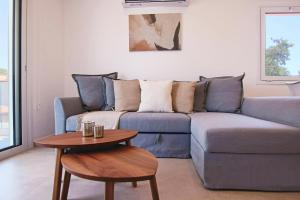 a living room with a blue couch and a table at Phaedrus Living Seaside Luxury Limnaria 172 in Paphos City