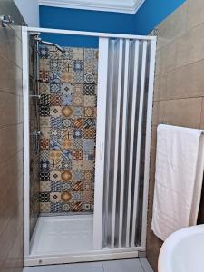 La salle de bains est pourvue d'une douche avec une porte en verre. dans l'établissement Sofi House, à Santo Stefano di Camastra