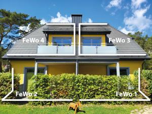 uma casa amarela com uma cerca em frente em Ferienhaus Triftweg 10 em Kolpinsee
