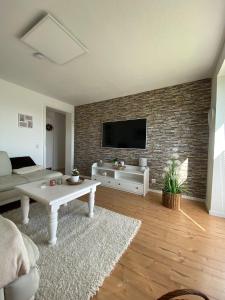 ein Wohnzimmer mit einem TV an einer Backsteinwand in der Unterkunft Buhr's Sonnenstern in Stolk