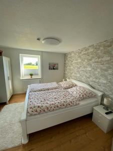 ein Schlafzimmer mit einem Bett und einer Ziegelwand in der Unterkunft Buhr's Sonnenstern in Stolk