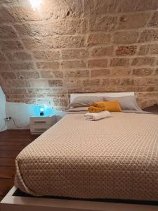 1 dormitorio con cama y pared de ladrillo en Suite San Pietro, en Galatina