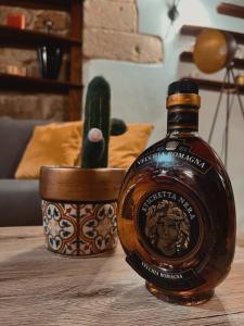 una botella de whisky en una mesa junto a un cactus en Suite San Pietro, en Galatina